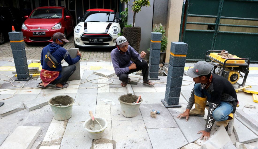 Pekerja menyelesaikan proyek revitalisasi trotoar di Jalan Suryo, Jakarta Selatan, Selasa (2/11). Penataan trotoar dilakukan dengan konsep penataan complete street, yaitu penataan ulang ruas jalan sesuai dengan fungsinya untuk mengakomodir seluruh kebutuhan pengguna jalan sesuai porsi yang tepat dengan memprioritaskan pejalan kaki, pesepeda, dan pengguna transportasi umum. - JPNN.com