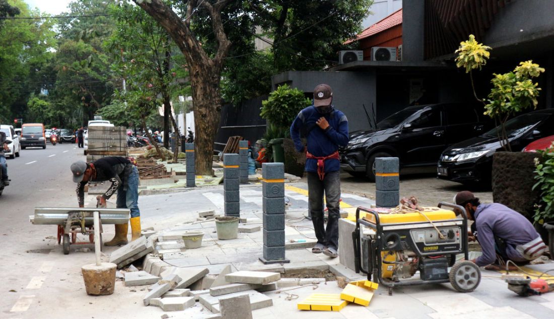 Pekerja menyelesaikan proyek revitalisasi trotoar di Jalan Suryo, Jakarta Selatan, Selasa (2/11). Penataan trotoar dilakukan dengan konsep penataan complete street, yaitu penataan ulang ruas jalan sesuai dengan fungsinya untuk mengakomodir seluruh kebutuhan pengguna jalan sesuai porsi yang tepat dengan memprioritaskan pejalan kaki, pesepeda, dan pengguna transportasi umum. - JPNN.com