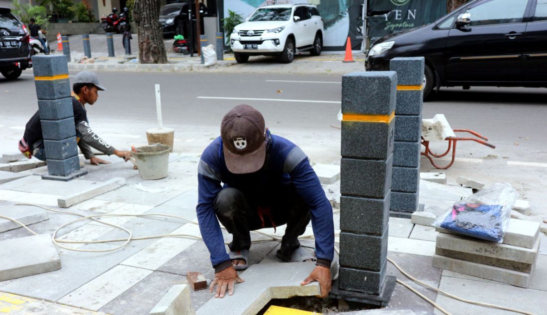 Pekerja menyelesaikan proyek revitalisasi trotoar di Jalan Suryo, Jakarta Selatan, Selasa (2/11). Penataan trotoar dilakukan dengan konsep penataan complete street, yaitu penataan ulang ruas jalan sesuai dengan fungsinya untuk mengakomodir seluruh kebutuhan pengguna jalan sesuai porsi yang tepat dengan memprioritaskan pejalan kaki, pesepeda, dan pengguna transportasi umum. - JPNN.com