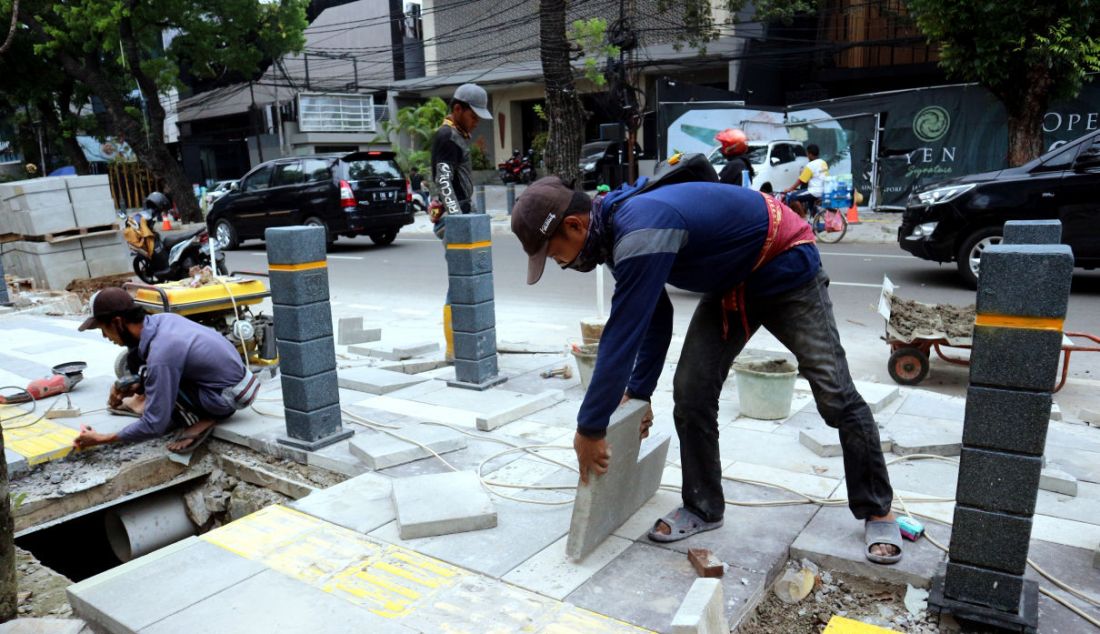 Pekerja menyelesaikan proyek revitalisasi trotoar di Jalan Suryo, Jakarta Selatan, Selasa (2/11). Penataan trotoar dilakukan dengan konsep penataan complete street, yaitu penataan ulang ruas jalan sesuai dengan fungsinya untuk mengakomodir seluruh kebutuhan pengguna jalan sesuai porsi yang tepat dengan memprioritaskan pejalan kaki, pesepeda, dan pengguna transportasi umum. - JPNN.com