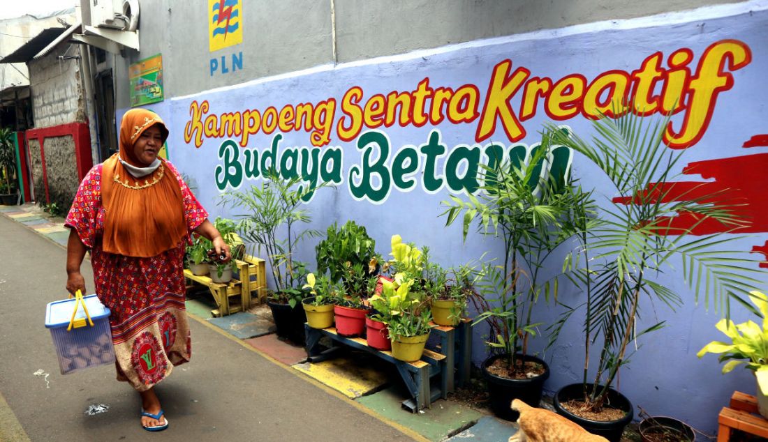 Warga melintas di lorong gang bergambar mural dengan tema budaya Betawi di kawasan Kampung Sentra Kreatif di RW 006 Kota Bambu Selatan, Palmerah, Jakarta Barat, Selasa (2/11). Pengembangan kawasan perkampungan ini bertujuan untuk menggugah semangat masyarakat untuk melestarikan budaya serta memberdayakan potensi perekonomian masyarakat, baik kuliner, jasa, maupun tanaman obat. - JPNN.com