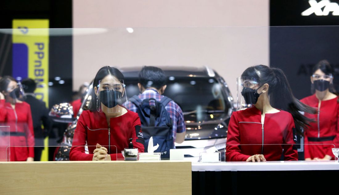 Penjaga stan Gaikindo Indonesia International Auto Show (GIIAS) 2021 di ICE BSD City, Tangerang Selatan, Kamis (11/11), mengenakan masker dan menjaga jarak fisik dalam rangka penerapan protokol kesehatan untuk mencegah penularan Covid-19. - JPNN.com