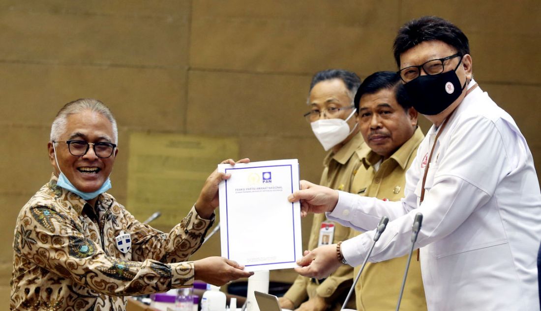 Menpan RB Tjahjo Kumolo (kanan) menerima pandangan fraksi dari Anggota DPR fraksi PAN Guspardi Gaus (kiri) saat mengikuti rapat pleno bersama Badan Legislasi DPR di Gedung DPR, Jakarta, Senin (22/11). Rapat pleno tersebut untuk mengambil keputusan atas hasil pembahasan RUU tentang pembentukan pengadilan tinggi, pengadilan tinggi agama, dan pengadilan tinggi tata usaha negara di sejumlah daerah salah satunya adalah di Papua Barat. - JPNN.com