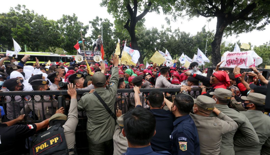 Sejumlah anggota serikat buruh melakukan aksi di depan Balai Kota Jakarta, Senin, (29/11). - JPNN.com