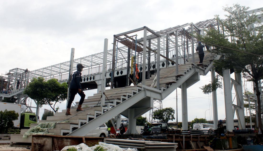 Pekerja membangun Jembatan Penyeberangan Orang (JPO) di kawasan Kalijodo, Jakarta, Rabu (1/12). Pembangunan JPO tersebut berfungsi untuk memudahkan masyarakat yang akan menyeberang ke RPTRA Kalijodo. - JPNN.com