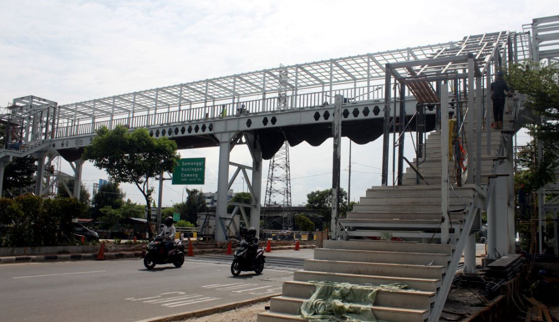 Pekerja saat melakukan pembangunan Jembatan Penyeberangan Orang (JPO) di kawasan Kalijodo, Jakarta, Rabu (1/12). Pembangunan JPO tersebut berfungsi untuk memudahkan masyarakat yang akan menyebrang ke RPTRA Kalijodo. - JPNN.com