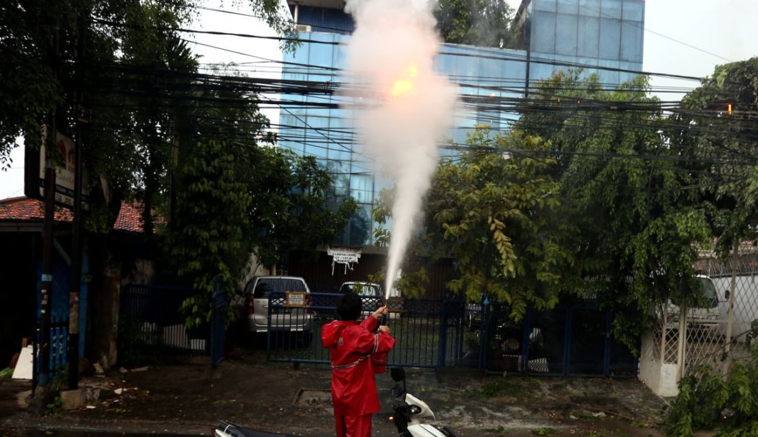 Petugas berusaha memadamkan kabel listrik terbakar akibat pohon tumbang di kawasan Jalan Raya Kebayoran Lama, Jakarta, Sabtu (11/12). - JPNN.com