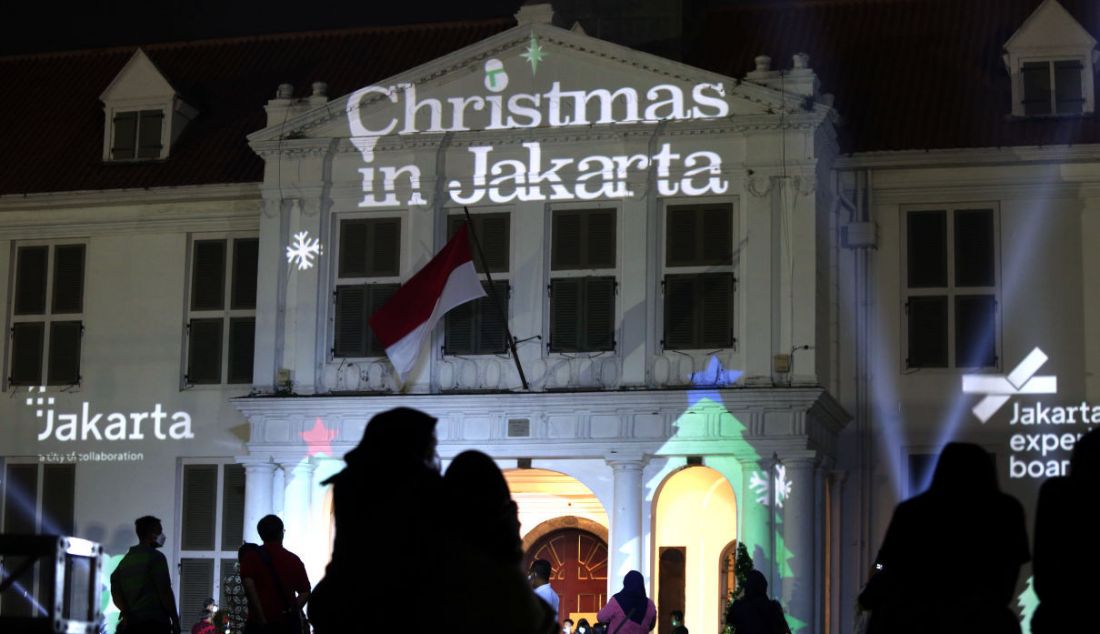 Warga menyaksikan video mapping bernuansa Natal yang ditampilkan saat acara 'Christmas in Jakarta' di Museum Fatahillah, Kota Tua, Jakarta, Senin (20/12). Pemerintah Provinsi DKI Jakarta menggelar acara 'Christmas in Jakarta' dengan tema Harmony with History dalam rangka menyambut perayaan Natal 2021. - JPNN.com