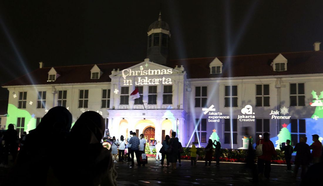 Warga menyaksikan video mapping bernuansa Natal yang ditampilkan saat acara 'Christmas in Jakarta' di Museum Fatahillah, Kota Tua, Jakarta, Senin (20/12). Pemerintah Provinsi DKI Jakarta menggelar acara 'Christmas in Jakarta' dengan tema Harmony with History dalam rangka menyambut perayaan Natal 2021. - JPNN.com