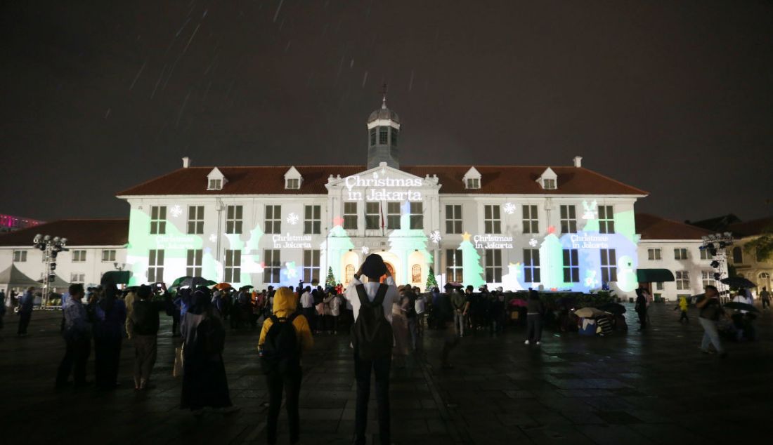 Warga menyaksikan video mapping bernuansa Natal yang ditampilkan saat acara 'Christmas in Jakarta' di Museum Fatahillah, Kota Tua, Jakarta, Senin (20/12). Pemerintah Provinsi DKI Jakarta menggelar acara 'Christmas in Jakarta' dengan tema Harmony with History dalam rangka menyambut perayaan Natal 2021. - JPNN.com