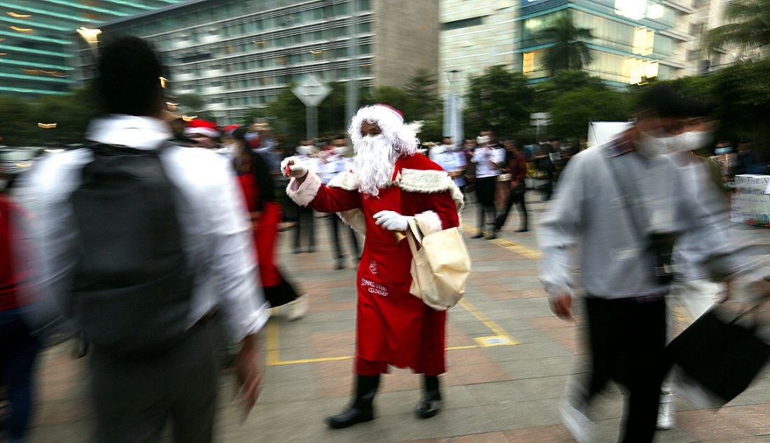 Petugas berkostum Santa Claus di jalur pedestrian kawasan Bundaran HI, Jakarta, Selasa (21/12). - JPNN.com