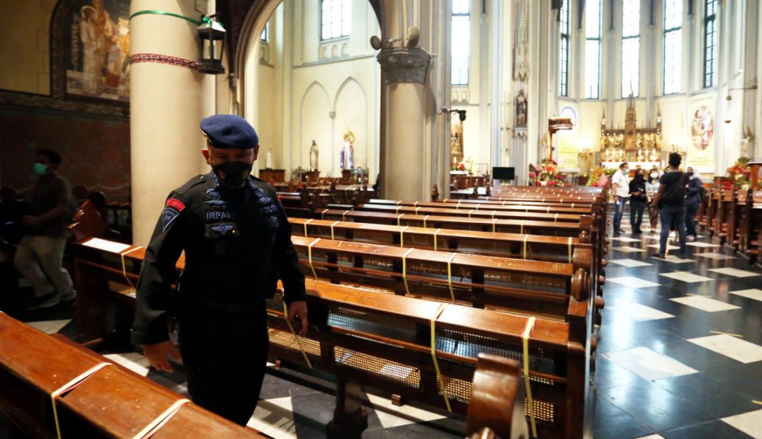 Anggota polisi mengecek keamanan Gereja Katedral, Jakarta, Jumat (24/12). - JPNN.com