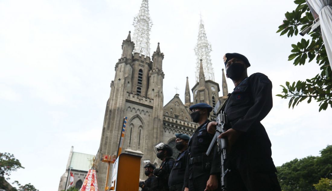 Anggota polisi menjaga Gereja Katedral, Jakarta, Jumat (24/12). Pengamanan di Gereja Katedral sebanyak 100 personel terdiri dari Polres Metro Jakarta Pusat, Polsek Sawah Besar, Satbrimob Polda Metro Jaya, Satpol PP. - JPNN.com