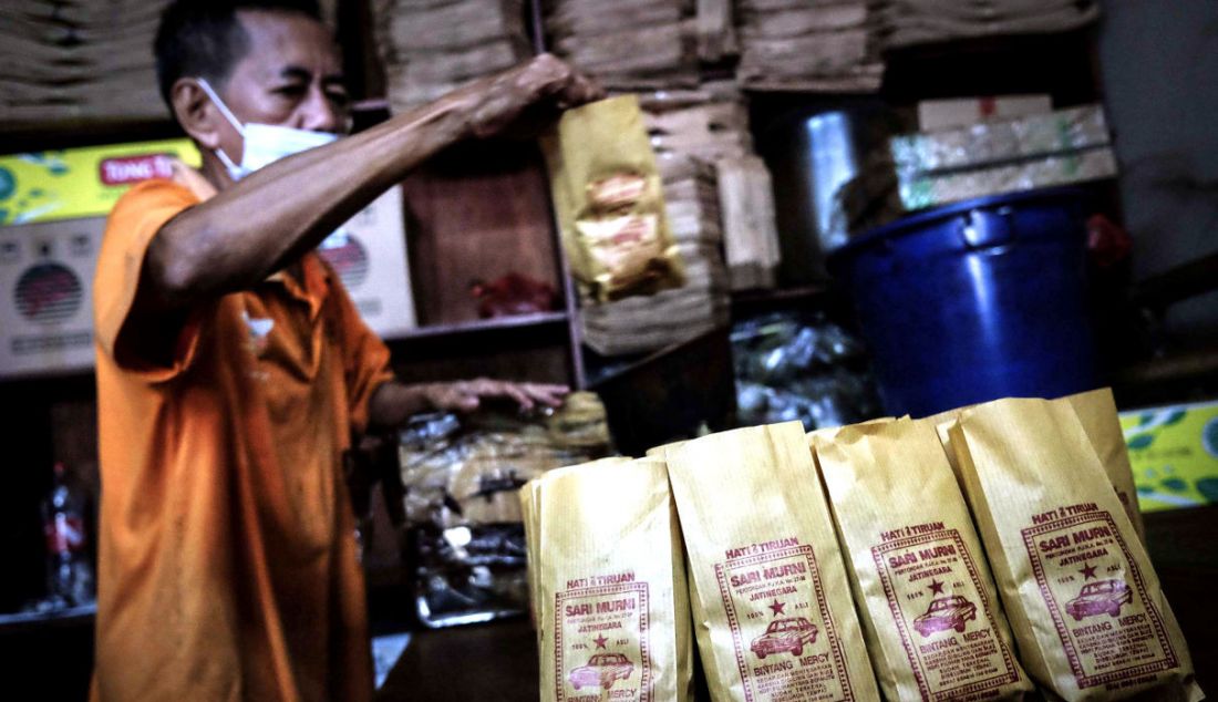 Pekerja saat mengemas kopi yang telah digiling ke dalam bungkus khas Kopi Sari Murni, Jatinegara, Jakarta, Kamis (6/1). Toko kopi yang berdiri sejak 1952 ini juga dikenal dengan Kopi Cap Sedan. - JPNN.com