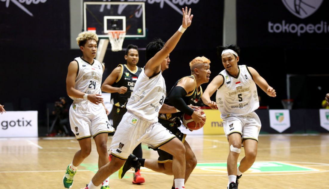 Pemain Dewa United Surabaya berusaha melewati pemain DNA Bima Perkasa Jogja pada pertandingan Seri 1 Jakarta Indonesian Basketball League (IBL) 2022 di Hall Basket Senayan, GBK, Jakarta, Senin (17/1). - JPNN.com