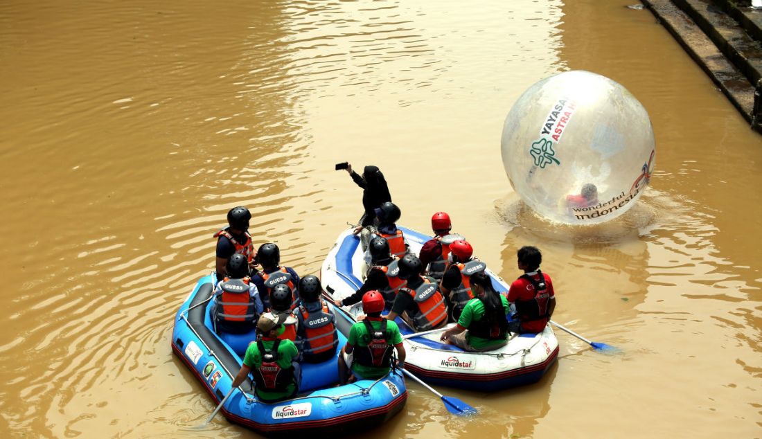 Sejumlah pengunjung menaiki perahu karet saat wisata susur Sungai Ciliwung di Kampung Labirin, Kebon Jukut, Kota Bogor, Jawa Barat, Minggu (30/1). - JPNN.com