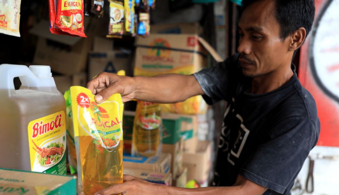 Pedagang saat merapikan minyak goreng. Pemerintah mengancam penjual dan pengecer yang menjual minyak goreng di atas harga Rp 14 ribu per liter dengan sanksi pencabutan izin usaha. - JPNN.com