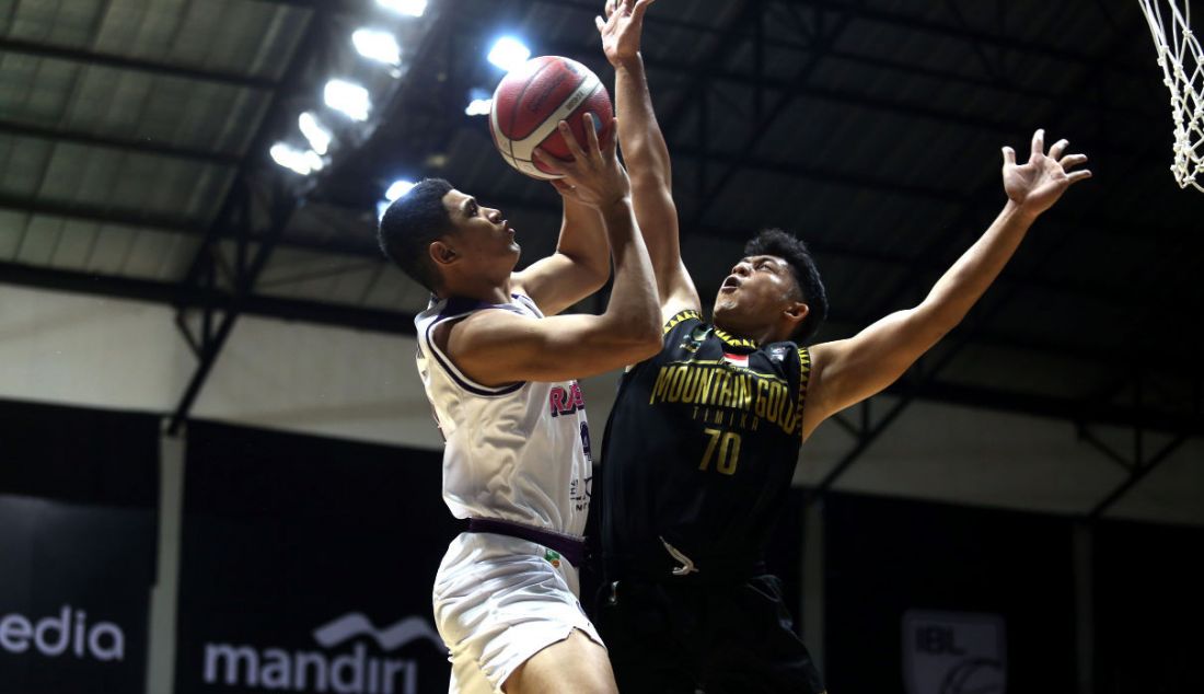 NSH Mountain Gold Timika mengadang jump shoot pemain RANS PIK Basketball Club pada pertandingan Indonesian Basketball League (IBL) 2022 di Hall Basket Senayan, GBK, Jakarta, Senin (7/3). - JPNN.com