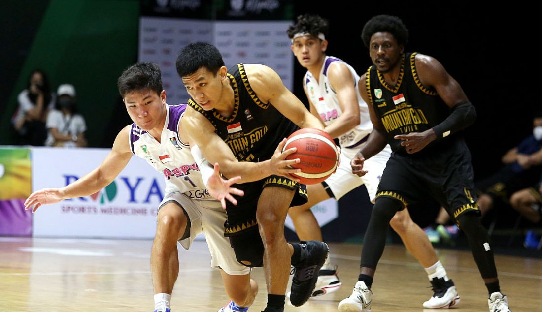 Pemain RANS PIK Basketball Club berusaha mencuri bola dari tangan pemain NSH Mountain Gold Timika pada pertandingan Indonesian Basketball League (IBL) 2022 di Hall Basket Senayan, GBK, Jakarta, Senin (7/3). - JPNN.com