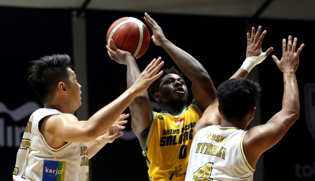 Pemain Satya Wacana Salatiga berusaha melewati adangan dua pemain West Bandits Combiphar Solo pada pertandingan Indonesian Basketball League (IBL) 2022 di Hall Basket Senayan, GBK, Jakarta, Senin (7/3). Satya Wacana Salatiga menang atas West Bandits Combiphar Solo dengan skor 73-64. - JPNN.com