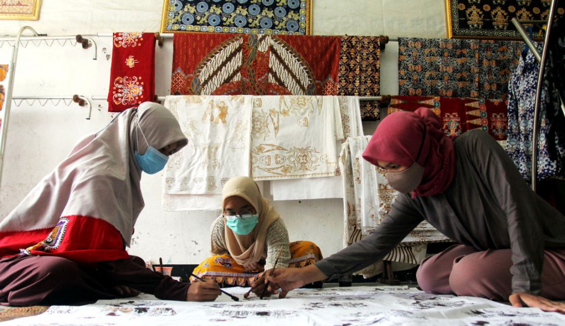 Pekerja menyelesaikan pembuatan batik tulis cetak di Batik Tradjumas, Pengasinan, Depok, Jawa Barat, Rabu (16/3). Produksi batik khas Kota Depok seperti Gong Si Bolong, Tugu Batu, Belimbing Dewa dan Ikan Hias tersebut mencapai 500 lembar per bulan yang dijual Rp 200 ribu hingga Rp 2 juta. - JPNN.com