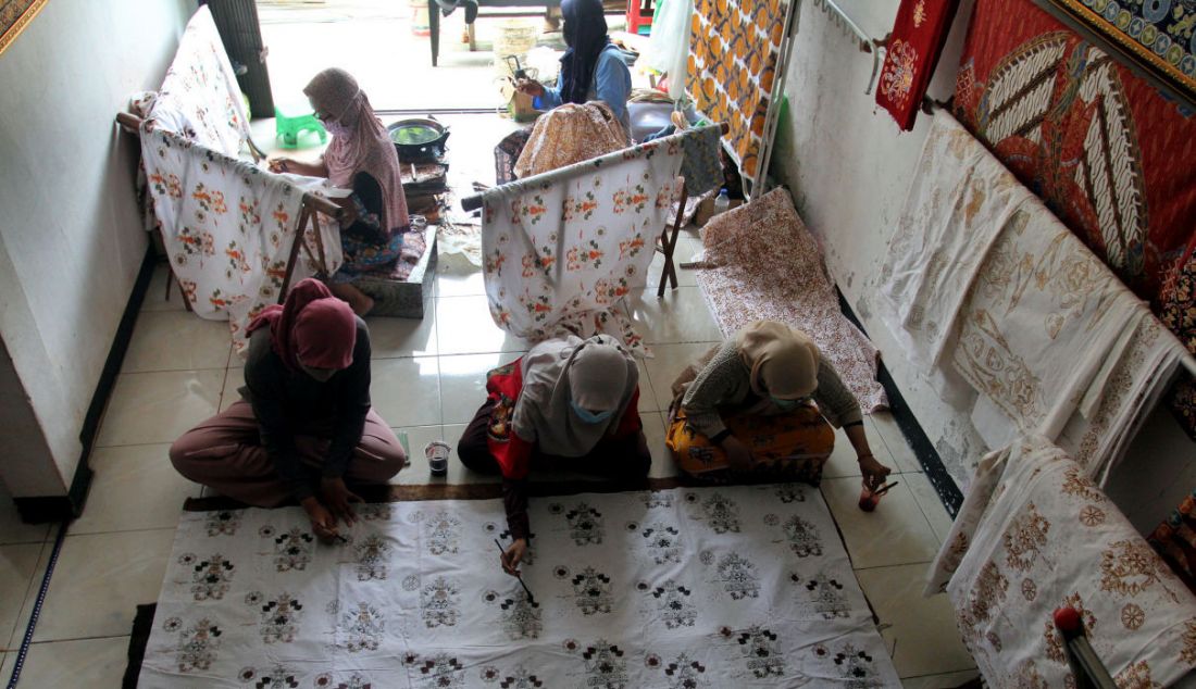 Pekerja menyelesaikan pembuatan batik tulis cetak di Batik Tradjumas, Pengasinan, Depok, Jawa Barat, Rabu (16/3). Produksi batik khas Kota Depok seperti Gong Si Bolong, Tugu Batu, Belimbing Dewa dan Ikan Hias tersebut mencapai 500 lembar per bulan yang dijual Rp 200 ribu hingga Rp 2 juta. - JPNN.com