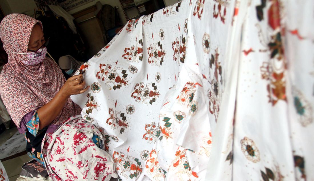 Pekerja menyelesaikan pembuatan batik tulis cetak di Batik Tradjumas, Pengasinan, Depok, Jawa Barat, Rabu (16/3). Produksi batik khas Kota Depok seperti Gong Si Bolong, Tugu Batu, Belimbing Dewa dan Ikan Hias tersebut mencapai 500 lembar per bulan yang dijual Rp 200 ribu hingga Rp 2 juta. - JPNN.com