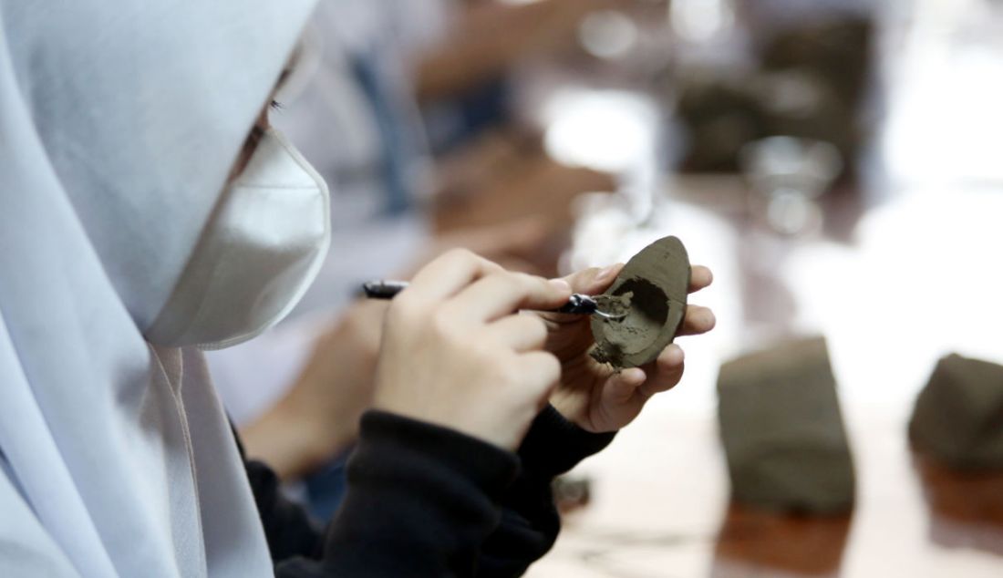 Pelajar menunjukkan suling tanah yang dibuatnya pada workshop Kongres Para Tanah di Museum Tanah Pertanian, Bogor, Jawa Barat, Rabu (23/3). Kongres Para Tanah mengajukan strategi kebudayaan dan bagaimana komunitas menjadi bagian pembangunan kultural, khususnya membayangkan ruang hidup yang berkelanjutan. - JPNN.com