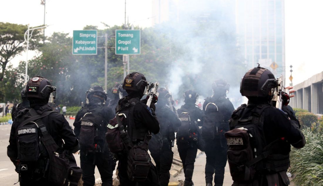 Aparat kepolisian melepaskan gas air mata untuk membubarkan massa demo 11 April di depan gerbang Gedung MPR/DPR/DPD, Jakarta. - JPNN.com