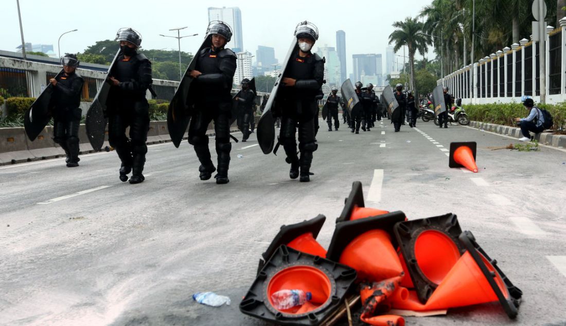 Aparat kepolisian membawa tameng menghalau massa demo 11 April di depan gerbang Gedung MPR/DPR/DPD, Jakarta, Senin (11/4). - JPNN.com