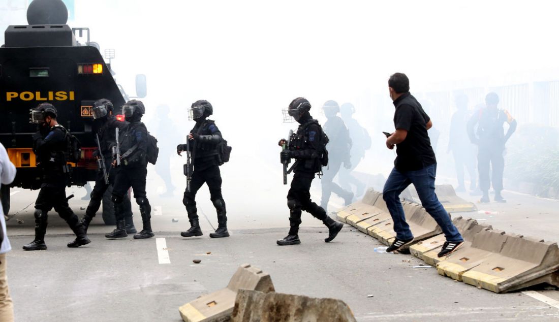 Aparat kepolisian menghalau massa demo 11 April dengan gas air mata di depan gerbang Gedung MPR/DPR/DPD, Jakarta, Senin (11/4). - JPNN.com