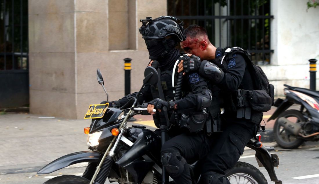 Seorang aparat kepolisian terluka setelah bentrok dengan demonstran di depan gerbang Gedung MPR/DPR/DPD, Jakarta, Senin (11/4). - JPNN.com