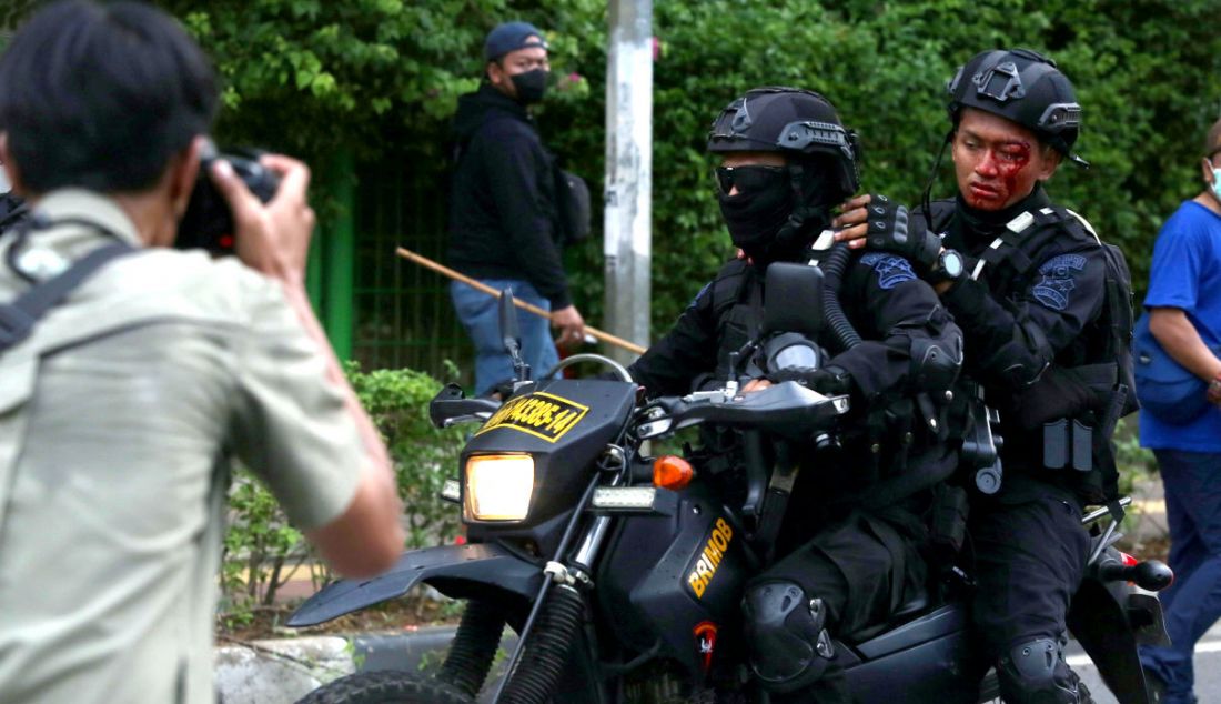 Seorang aparat kepolisian terluka setelah bentrok dengan demonstran di Jakarta, Senin (11/4). - JPNN.com