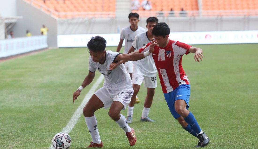 Pemain Bali United U18 I Komang Aldita Maha Putra berusaha mempertahankan bola pada pertandingan International Youth Championship di Jakarta Internasional Stadium, Jakarta, Rabu (13/4). Atletico De Madrid menang atas Bali United U18 dengan skor 5-0. - JPNN.com