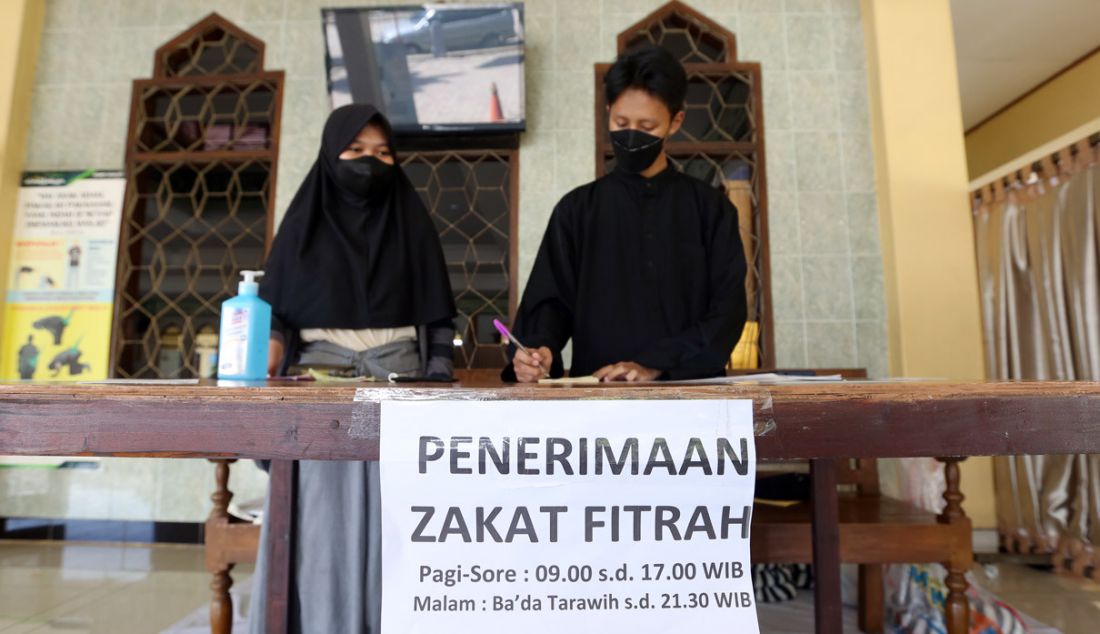 Petugas menerima pembayaran zakat fitrah di Masjid Al Muttaqien Pura Bojonggede, Tajur Halang, Kabupaten Bogor, Jawa Barat, Minggu (24/4). Memasuki delapan hari terakhir Ramadan, warga mulai menyerahkan zakat fitrah sebagai kewajiban umat Islam menjelang Idulfitri. - JPNN.com