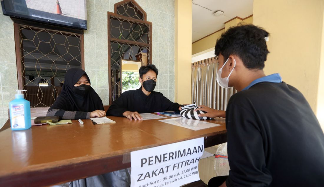 Petugas menerima pembayaran zakat fitrah di Masjid Al Muttaqien Pura Bojonggede, Tajur Halang, Kabupaten Bogor, Jawa Barat, Minggu (24/4). Memasuki delapan hari terakhir Ramadan, warga mulai menyerahkan zakat fitrah sebagai kewajiban umat Islam menjelang Idulfitri. - JPNN.com