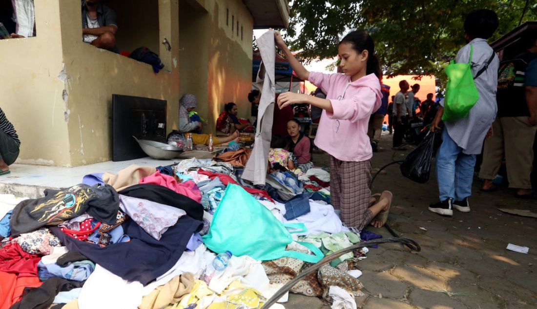 Warga korban kebakaran di Pasar Gembrong saat melihat kondisi pakaian seusai kios mereka terbakar, Jakarta, Senin (25/4). - JPNN.com