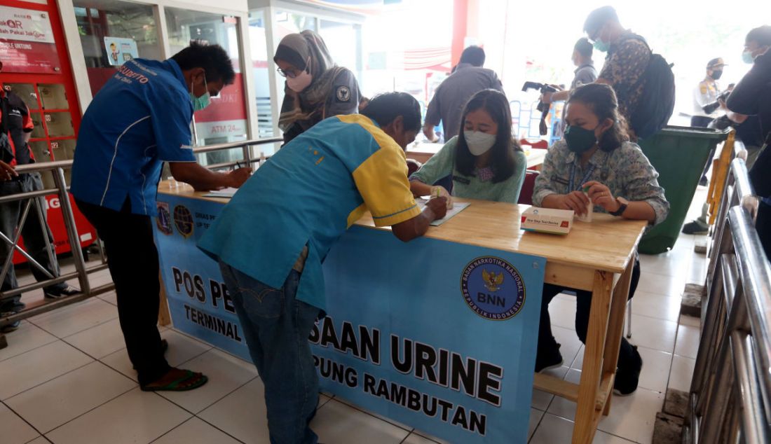 Petugas memeriksa urine sopir bus di Terminal Kampung Rambutan, Jakarta, Rabu (27/4). - JPNN.com