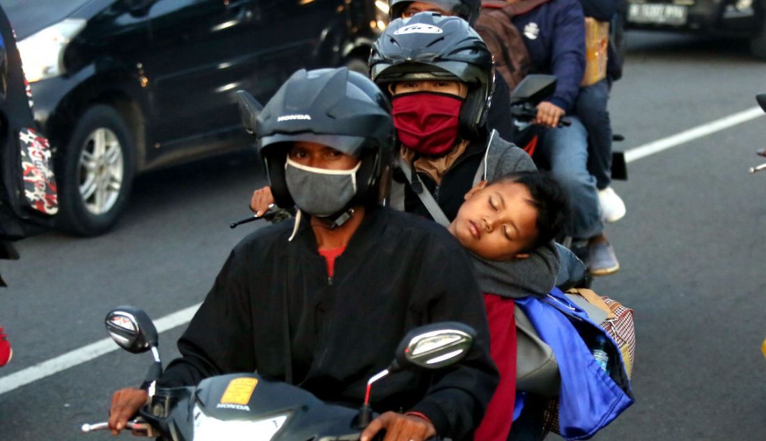 Seorang balita tertidur di pelukan ibunya saat melintasi jalur mudik Simpang Jomin, Karawang, Jawa Barat, Jumat (29/4). - JPNN.com