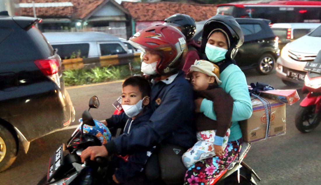 Seorang balita tertidur di pelukan ibunya saat melintasi jalur mudik Simpang Jomin, Karawang, Jawa Barat, Jumat (29/4). - JPNN.com