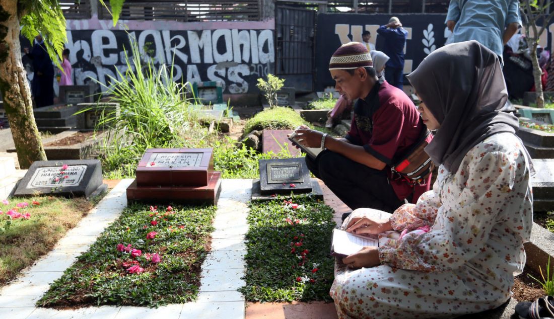 Umat Islam berdoa di depan makam keluarga dan kerabat dekat di Tempat Pemakaman Umum Blender, Kebon Pedes, Kota Bogor, Jawa Barat, Senin (2/5). Mayoritas muslim ziarah makam mendoakan mendiang keluarga dan kerabat mereka setelah melaksanakan salat Idulfitri. - JPNN.com