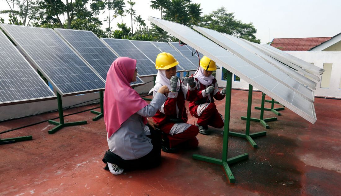 Seorang guru saat mengajarkan praktek perawatan solar panel di SMK N 1 Kemang, Bogor, Jawa Barat, Kamis (19/5). Solar panel menghasilkan energi listrik yang digunakan untuk kebutuhan pasokan listrik di lab sekolah tersebut. - JPNN.com