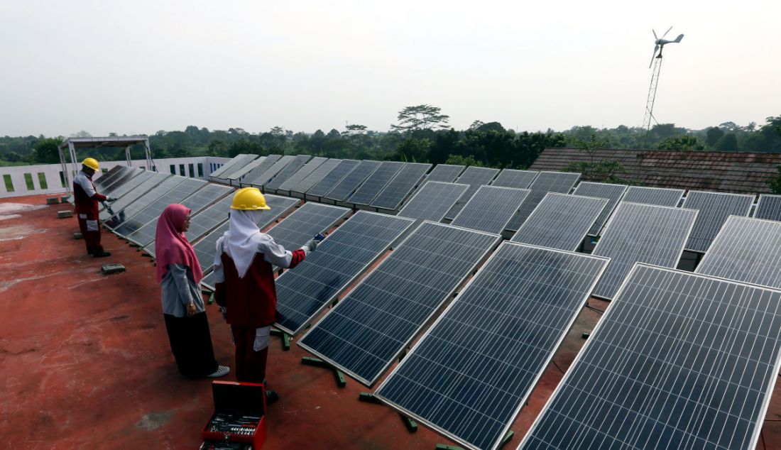 Seorang guru saat mengajarkan praktek perawatan solar panel di SMK N 1 Kemang, Bogor, Jawa Barat, Kamis (19/5). Solar panel menghasilkan energi listrik yang digunakan untuk kebutuhan pasokan listrik di lab sekolah tersebut. - JPNN.com