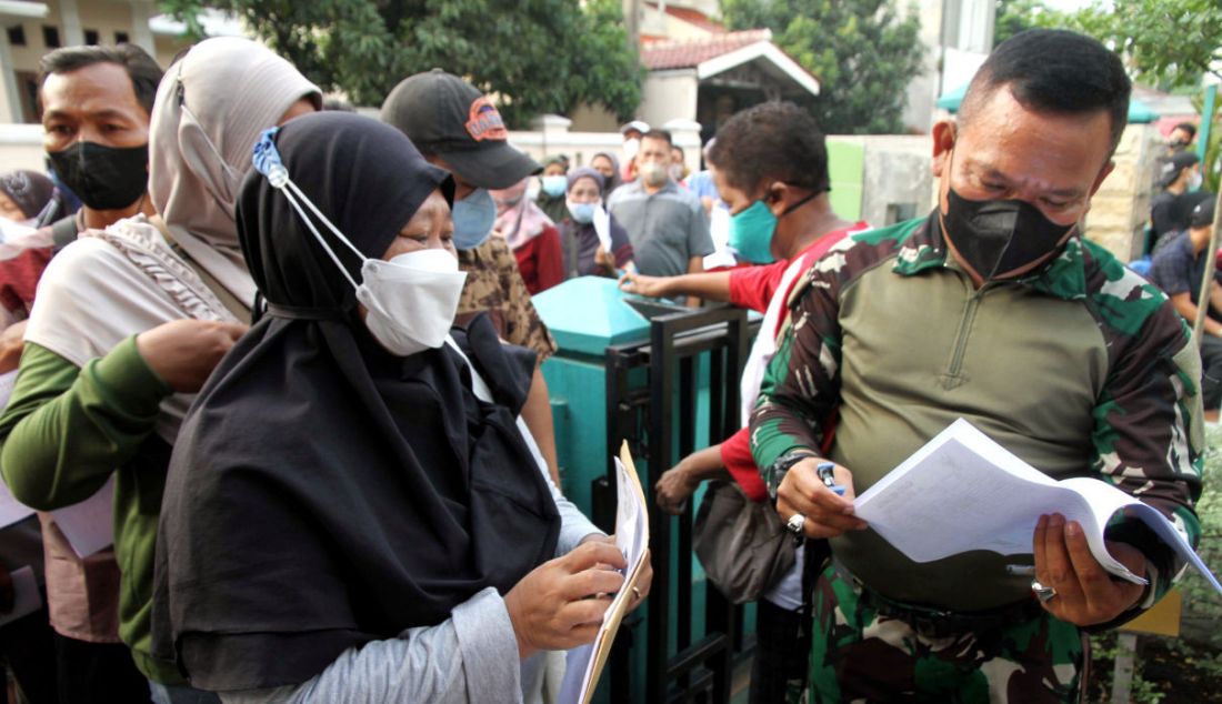 Warga antre mencairkan bantuan langsung tunai (BLT) minyak goreng di Kantor Koramil 02/Beji, Depok, Jawa Barat, Kamis (19/5). - JPNN.com