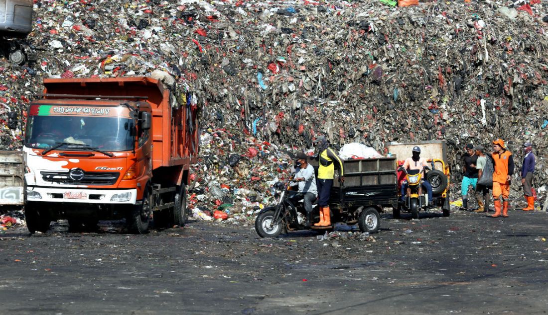 Petugas menggunakan alat berat untuk mengangkut sampah di Tempat Pembuangan Akhir (TPA) Cipayung, Depok, Jawa Barat, Selasa (24/5). - JPNN.com