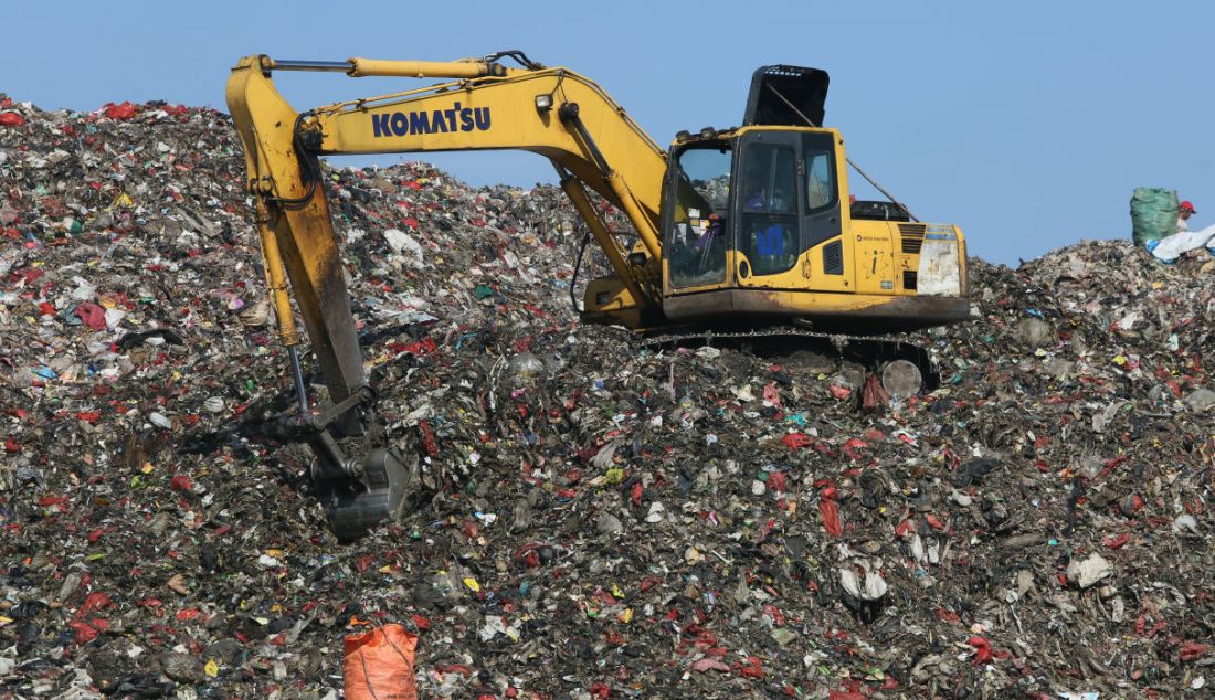 Petugas menggunakan alat berat untuk mengangkut sampah di Tempat Pembuangan Akhir (TPA) Cipayung, Depok, Jawa Barat, Selasa (24/5). - JPNN.com