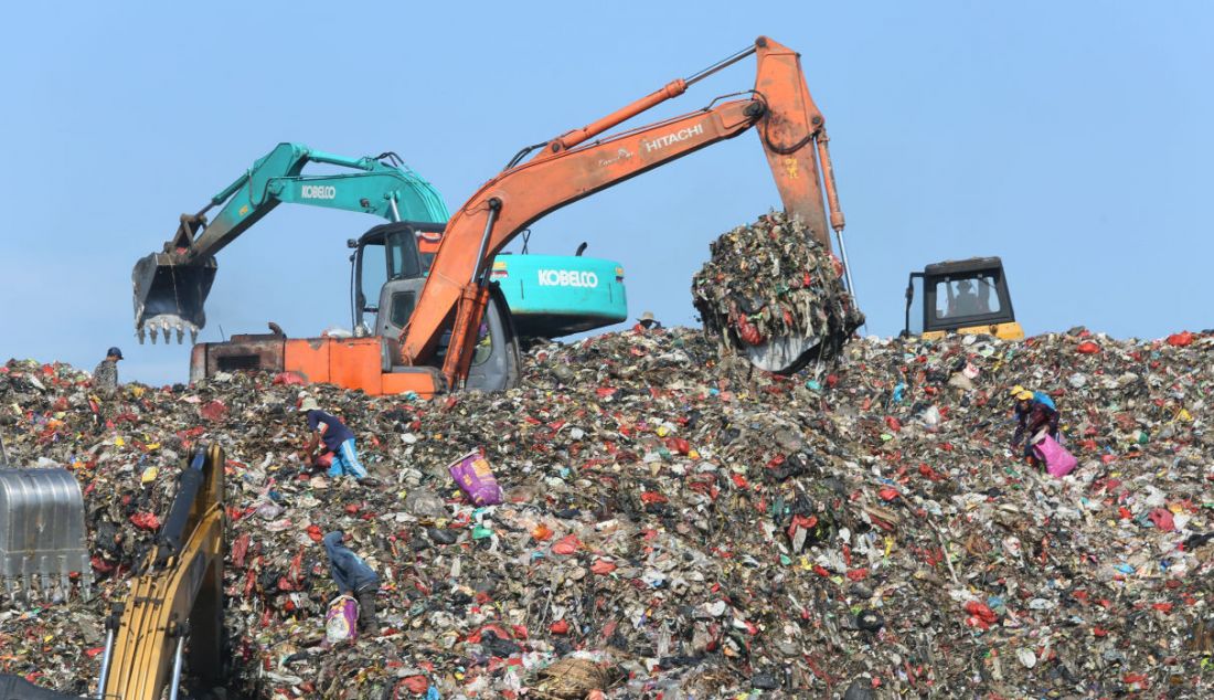 Petugas menggunakan alat berat untuk mengangkut sampah di Tempat Pembuangan Akhir (TPA) Cipayung, Depok, Jawa Barat, Selasa (24/5). - JPNN.com