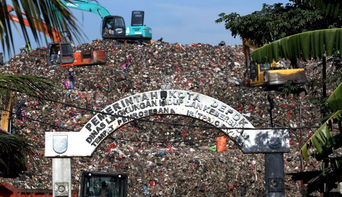 Petugas menggunakan alat berat untuk mengangkut sampah di Tempat Pembuangan Akhir (TPA) Cipayung, Depok, Jawa Barat, Selasa (24/5). - JPNN.com