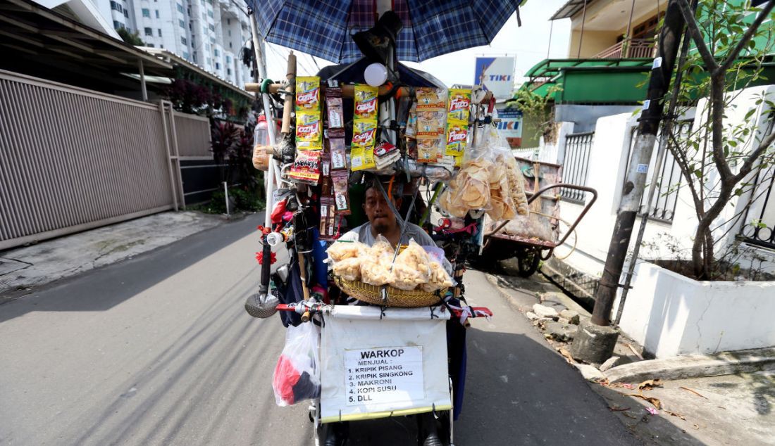 Kundiarto bersama istrinya berjualan di atas kursi roda di kawasan Cipete Utara, Jakarta, Kamis (2/6). Di atas kursi roda yang didorong hingga sekitar 10 kilometer oleh istrinya, Kundiarto sehari-harinya berjualan kopi dan aneka makanan ringan. Dalam sehari, pria yang mengontrak rumah di Jalan Damai 5, Gang Haji Amu 5, RT 13/02 ini mendapatkan penghasilan mulai dari Rp 50 ribu hingga Rp 100 ribu. - JPNN.com
