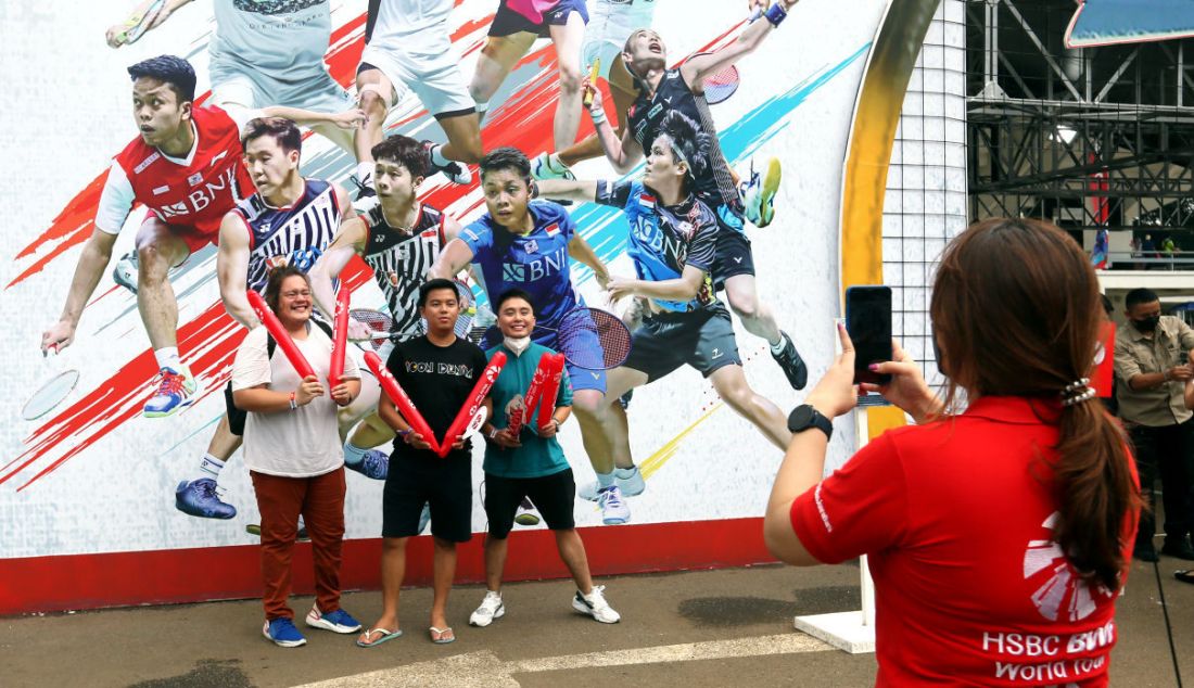 Warga berfoto dengan latar belakang atlet bulu tangkis peserta Daihatsu Indonesia Master 2022 di Istora Senayan, Jakarta, Rabu (8/6). - JPNN.com